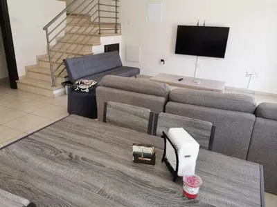 a living room with a couch and a tv at Mythical Sands BG03 townhouse in Paralimni
