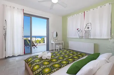 a bedroom with a large bed and a large window at Villa Sea Horizon in Protaras