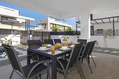a black dining room table and chairs in front of a house at Villa Daniella in Protaras