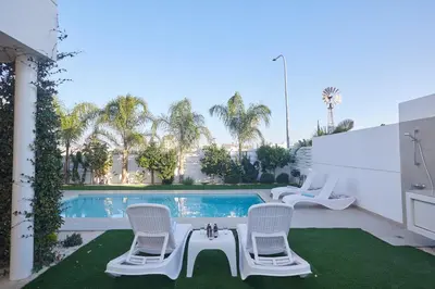 a patio with two chairs and a swimming pool at Protaras Vie Bleu Villa Vb8 in Protaras