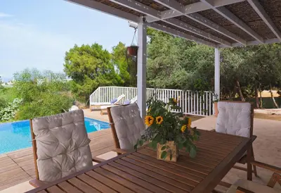 a wooden table with chairs and a vase of sunflowers at Villa Orchard by Tangerine in Protaras