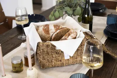 a basket of bread on a table with glasses of wine at Villa Orchard by Tangerine in Protaras