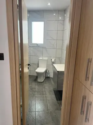 a bathroom with a toilet and a sink and a window at Oceania bay village Pyla in Larnaka