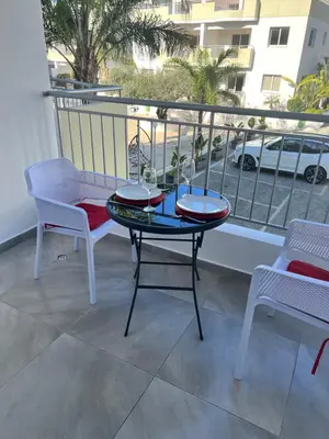 a table and two chairs on a balcony with a view at Oceania bay village Pyla in Larnaka