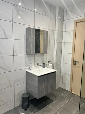 a white bathroom with a sink and a mirror at Oceania bay village Pyla in Larnaka