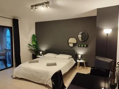 a bedroom with a white bed and a black wall at 303 St Lazaros View Studio in Larnaka
