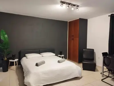 a bedroom with a white bed and a chair at 303 St Lazaros View Studio in Larnaka