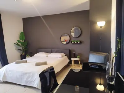 a bedroom with a bed and a chair and mirrors at 303 St Lazaros View Studio in Larnaka