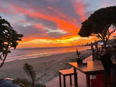 a person taking a picture of a sunset on the beach at Glabur Stays! The One -1 - Elite Marina Front! in Zygi