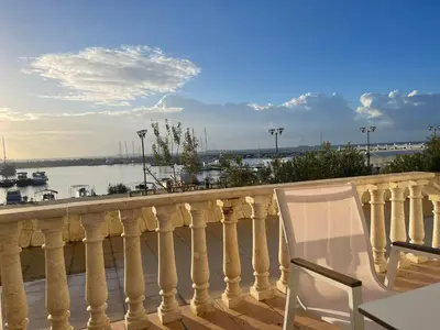 a white chair sitting on a balcony overlooking a marina at Glabur Stays! The One -1 - Elite Marina Front! in Zygi