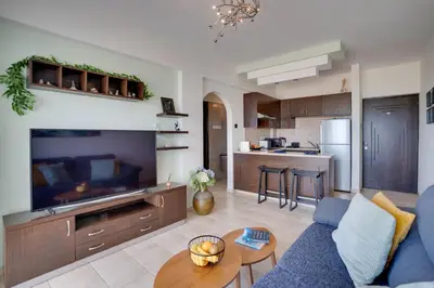 a living room with a blue couch and a kitchen at Glabur Stays! The One -1 - Elite Marina Front! in Zygi