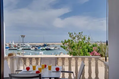 a table and chairs on a balcony with a marina at Glabur Stays! The One -1 - Elite Marina Front! in Zygi