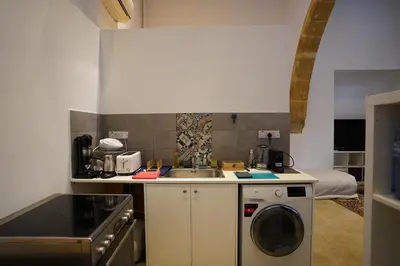 a kitchen with a sink and a washing machine at Large Kamara Studio in Nicosia