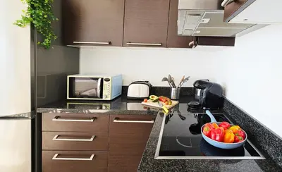 a kitchen with a microwave and a bowl of fruit on the counter at Dios Ponte Finikoudes Beachfront in Larnaka