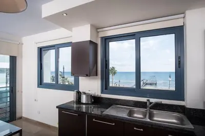 a kitchen with a sink and a view of the ocean at Dios Ponte Finikoudes Beachfront in Larnaka