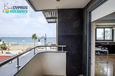 a view of the beach from the balcony of a building at Dios Ponte Finikoudes Beachfront in Larnaka