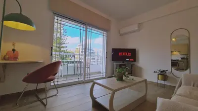 a living room with a tv and a couch and a table at STAY Sunlit Apartment in Limassol