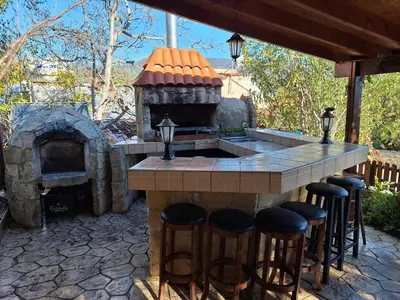 a large outdoor kitchen with a stone fireplace at Koukaki in Kouka