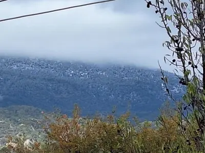 a foggy mountain with a city in the background at Koukaki in Kouka