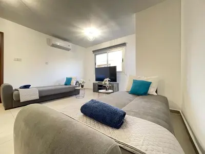 a living room with a large bed and a couch at Aurora Holiday Apartment - Ayia Napa in Ayia Napa