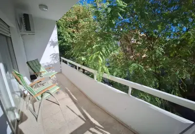 a balcony with two chairs and a large window at Cozy 2 Bdr Nicosia City Free Parking Wifi in Nicosia