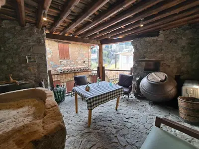 a living room with a table and a stone fireplace at PITHARIA in Askas