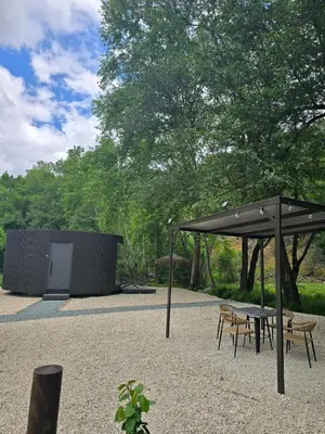 a pavilion with a table and chairs under a canopy at River Glamping Kalopanayiotis in Kalopanayiotis