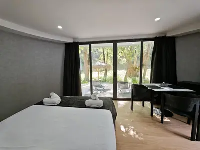 a bedroom with a bed and a dining room with a table at River Glamping Kalopanayiotis in Kalopanayiotis