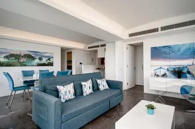 a living room with a blue couch and a table at Protaras Beachfront Thalassa Suite in Protaras