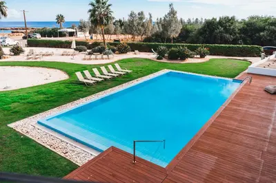 an empty swimming pool in a resort with a beach at Protaras Beachfront Thalassa Suite in Protaras