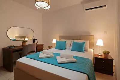 a bedroom with a bed with blue pillows and a mirror at Cape Panorama Villa in Protaras