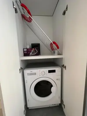 a laundry room with a washing machine and shelves at Johnny's luxury getaway in Strovolos