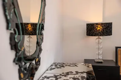 a bedroom with a mirror and two lamps on a bed at Hallmark Beach by TrulyCyprus in Limassol