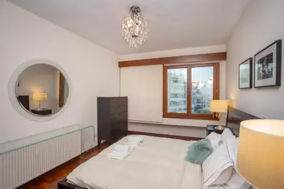 a bedroom with a large bed and a mirror at Hallmark Beach by TrulyCyprus in Limassol