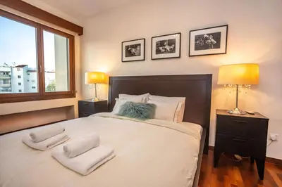 a bedroom with a bed with two lamps and a window at Hallmark Beach by TrulyCyprus in Limassol