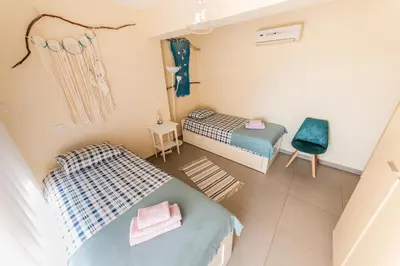 a small room with two beds and a chair at 3 bed, Kapparis, Thea - 3A in Paralimni