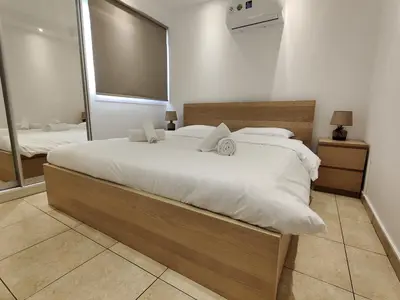 a bedroom with a large bed and a large mirror at Maestro II Apartment in Larnaka