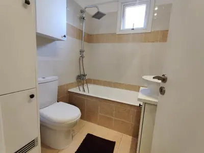a bathroom with a toilet and a tub and a sink at Maestro II Apartment in Larnaka