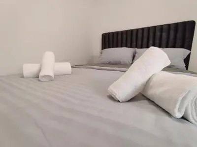 a bed with two rolled up towels on it at Maestro II Apartment in Larnaka