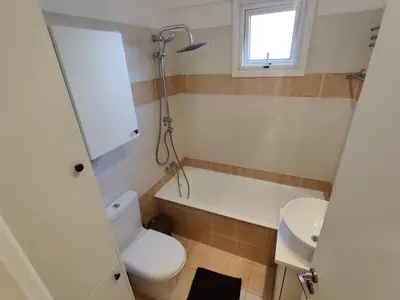 a bathroom with a toilet and a tub and a sink at Maestro II Apartment in Larnaka