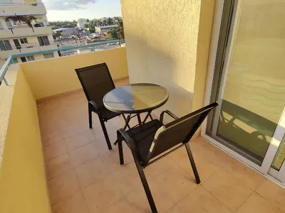a table and chairs on a balcony with a view at Maestro II Apartment in Larnaka