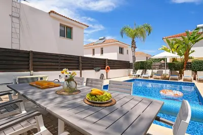 a table with fruit on it next to a swimming pool at Villa Maya - 4bed with Private Heated Pool in Paralimni