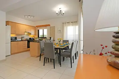 a kitchen and dining room with a table and chairs at Villa Maya - 4bed with Private Heated Pool in Paralimni