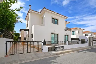 a white house with a black fence at Villa Maya - 4bed with Private Heated Pool in Paralimni