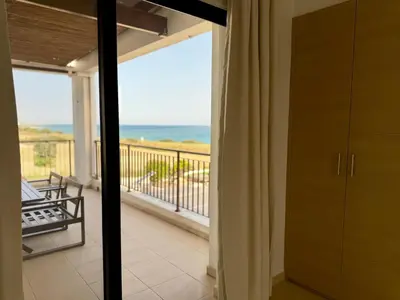 a room with a balcony with a view of the ocean at Villa Hera in Ayios Theodhoros