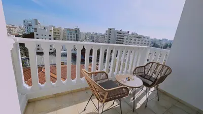 a balcony with two chairs and a table on a balcony at STAY Cosmo City Suites in Nicosia