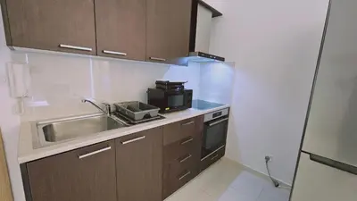 a small kitchen with a sink and a microwave at STAY Cosmo City Suites in Nicosia