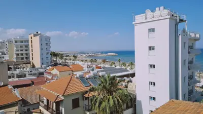a view of a city with a white building and the ocean at STAY Finikoudes Soul in Larnaka