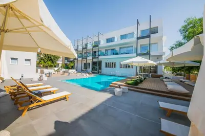 a swimming pool with chairs and umbrellas next to a building at Apartament De Lux MS 1 - C in Paralimni