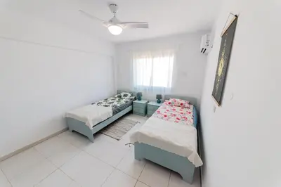 a small room with two beds and a window at 2 bed, Kapparis, Trinidad - 2A in Paralimni